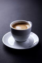 Cup of coffee on dark paper background. Soft focus. Close up. Copy space.	