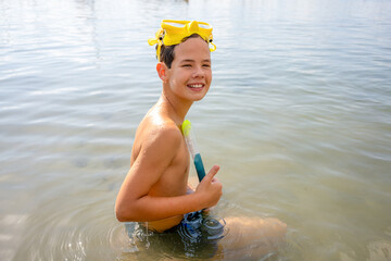 Portrait of happy cute boy wearing snorkeling mask ready to dive in the sea