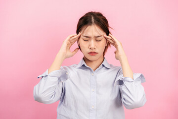 Young asian woman using fingers with both hands to touching and massaging forehead while suffering...