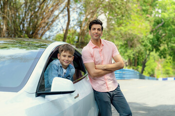 Fototapeta premium Dad and son on the road trip by the green nature countryside, family vholiday vacation concept. Young little boy enjoying family car adventure vacation with his father. Perpetual