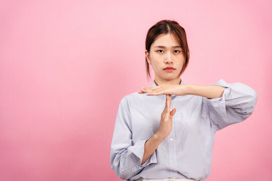 Young asian woman wearing long sleeve shirt and disappointed face while using both hands to showing time out