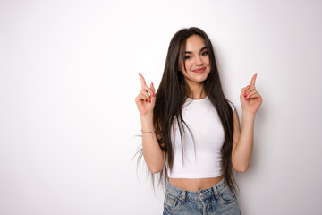 Happy young woman pointing up with both hands isolated on a white background