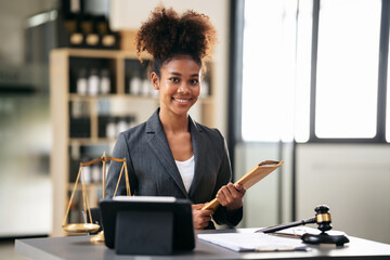 African american lawyer woman in suit holding envelope of business contract while sitting to working