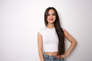 Portrait of lovely woman 20s with long hair wearing casual t-shirt smiling at you, isolated over white background