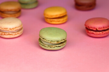 Colorful macarons on pink background. Selective focus.