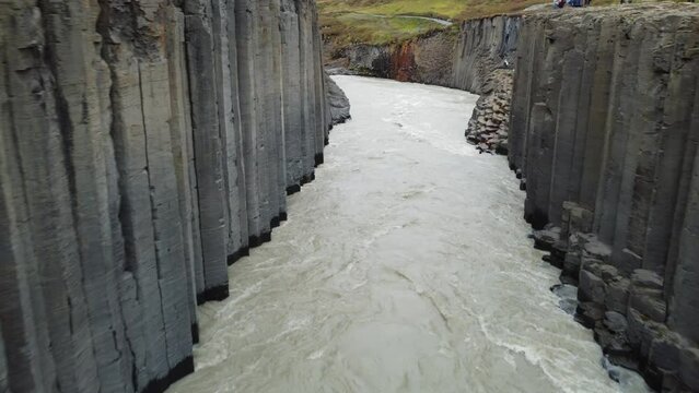 Vue a&eacute;rienne immersive de la vall&eacute;e Stu&eth;lagil avec rivi&egrave;re et roche volcanique, Islande