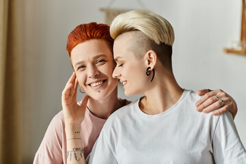 A lesbian couple with shaved heads strike a confident pose in a bedroom, embracing their unique...