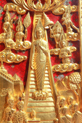 Ancient traditional Thai style door decorated with buddha story in a public temple in Bangkok.