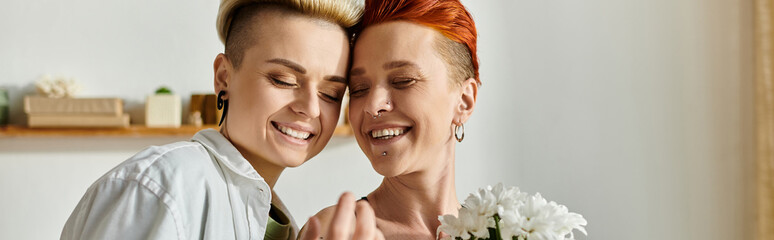 Two women with short hair pose in front of a mirror, showcasing their love and style with a...