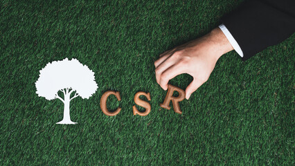 Hand arrange wooden alphabet text in CSR on biophilic background with Tree sign as eco symbol for...