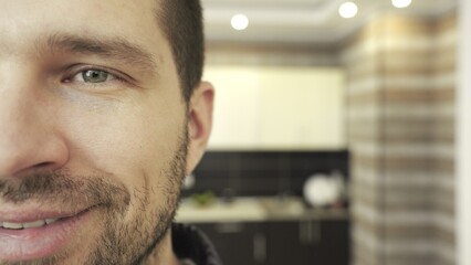 Young man showing half face on camera, showing happy facial expressions