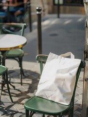 White blank tote bag resting against green chair mockup