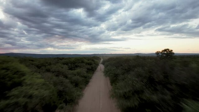 Camino de tierra vista a&eacute;rea de dron. Autos pasando por camino de ripio. Footage de saturaleza, campo, rural, aventura, ruta.