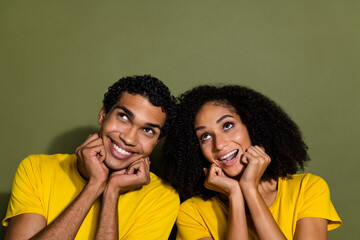 Portrait of two nice people look empty space wear t-shirt isolated on khaki color background