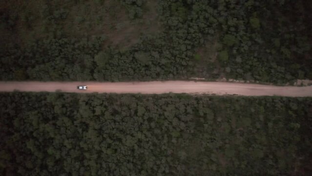 Camino de tierra vista a&eacute;rea cenital de dron. Autos pasando por camino de ripio. Footage de saturaleza, campo, rural, aventura, ruta.