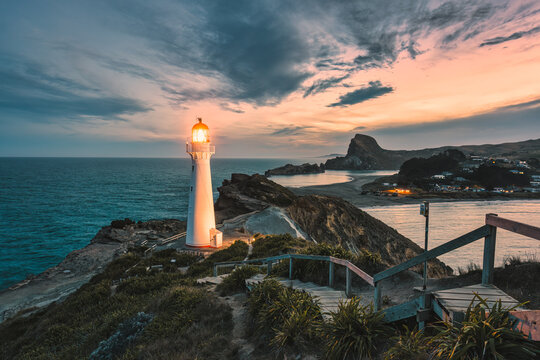 View of Castlepoint Lighthouse with beam on Wairarapa coast in the evening at New Zealand