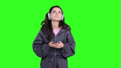 Sad woman wearing headphones and holding mobile phone on the chroma key