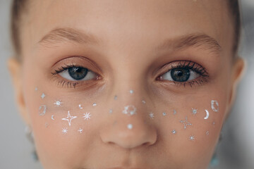 girl's eyes close-up, with stickers on nose, freckles stickers