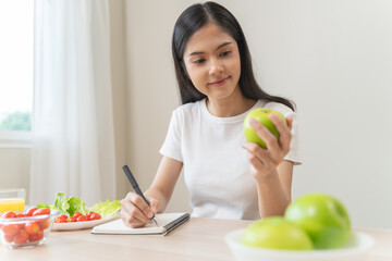 Wellbeing of health with good food control concept. Woman writing the meal note and plan to eat...