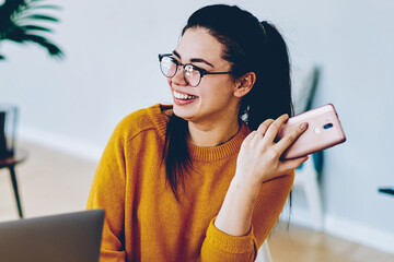 Cheerful caucasian woman joking with her boyfriend while making research together using modern...