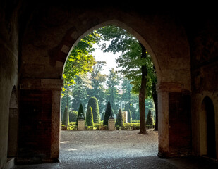 Vue sur le parc de la Piazza Pallone depuis une arche du palais ducal de Mantoue en Italie