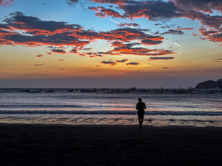 Naklejka premium Silhouette of a Couple in love watching the sunset at the magnificent San Juan Del Sur Beach in Nicaragua