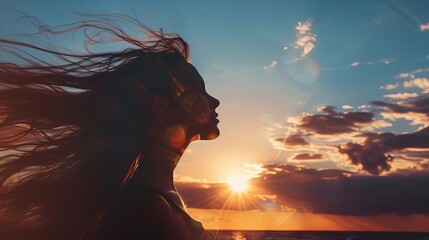 silhouette of woman with flowing hair against radiant sunset sky inspirational concept photo