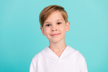 Portrait of cute boy happy emotions looking into photo camera isolated on cyan color background
