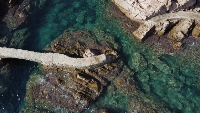 Drone view of one broken walkway in Meditteranean sea. Crystal clear water at Cam&iacute; de Ronda, Santa Cristina de Aro, Costa Brava, Catalonia, Spain.