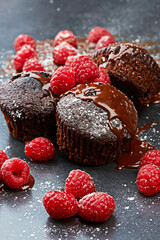 Berry, cupcake and fruit by dark background for chocolate, liquid and dessert with icing sugar. Raspberry, muffin and white powder on countertop with red color for bakery, rich taste and sweet food