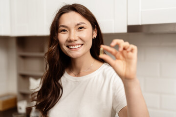 Young Asian Woman In Kitchen Holding Vitamin. Happy, Optimistic, Satisfaction Concept. Perfect for...