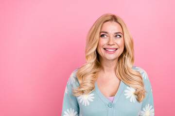 Photo of positive cheerful woman with wavy hairdo dressed print cardigan look at sale empty space isolated on pink color background
