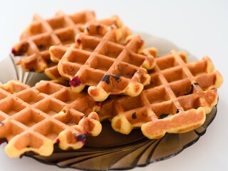 Gluten free homemade waffles on a plate on a white table.