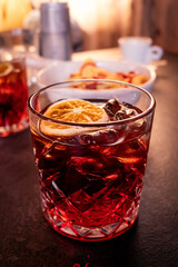 Negroni drink on a table in bar, alcoholic beverage with an orange garnish