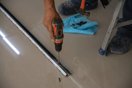 man use electrical drill to drilling  square steel bar