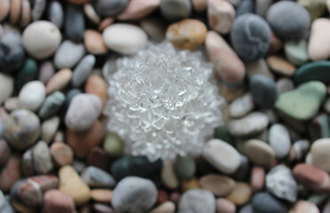 Clear Crystal In Flower Shape On Colored Pebbles Top View Stock Photo For Stones Backgrounds

