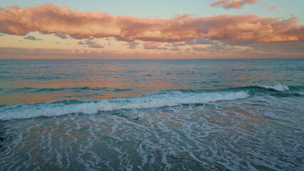 Aerial twilight ocean view. Golden hour bring vibrant colors to waves and surf