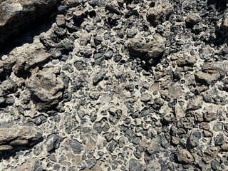 Solid lava rocks surface in the sun on the coast of El Medano, Tenerife, Canary Islands, Spain 