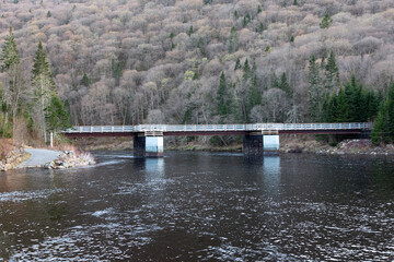 Small pedestrian bridge over the river in the Jacques-Cartier National Park in spring, Stoneham-et-Tewsksbury, Quebec, Canada