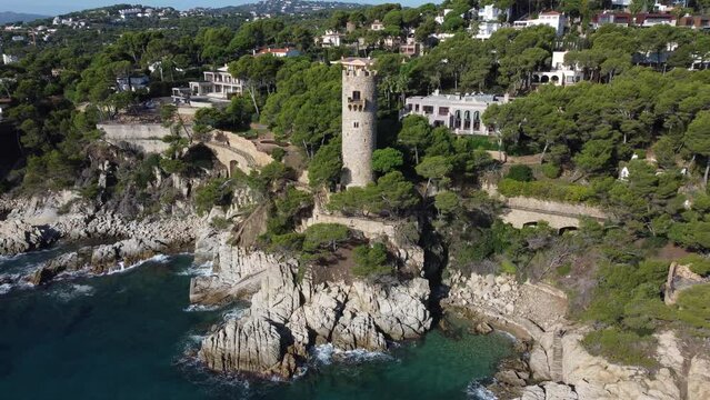 Drone view of Defense tower Torre dels Perpiny&agrave; in Cala de l'Embarcador inside the Cami de Ronda path, Costa Brava, Catalonia, Spain