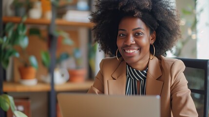 A cheerful professional woman works on her laptop in a vibrant office environment, surrounded by green plants, showcasing productivity and positivity..