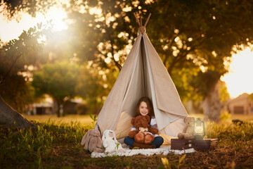 Teepee, tent and girl with toy in garden in nature for fun, playing and camping for adventure or...