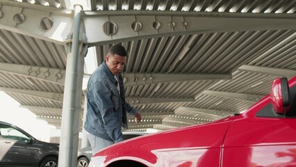 Male driver opening car hood on the parking in the city. .