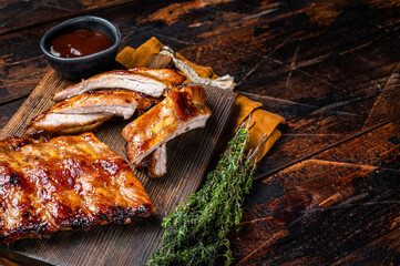 Grilled pork Baby Back spare ribs on a wooden board. Wooden background. Top view. Copy space