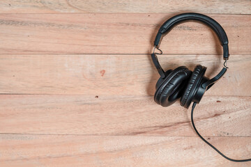 Black headphones isolated on wooden background