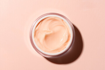 Open jar of pink peach beauty cream