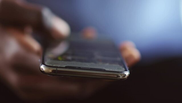 Online entertainment. African guy scrolling social media news feed on cellphone