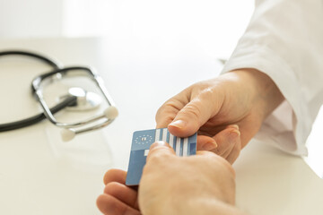 European health insurance card handed to doctor in doctor's office, Concept, Travel insurance,...
