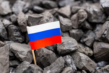 Russian coal. Energy and industrial concept. A coal heap with a Russian flag