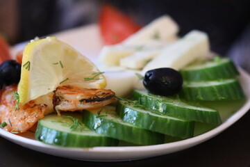 Fresh and delicious plate of cucumbers, olives, and shrimp. Perfect for food blogs or restaurant menus